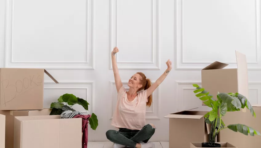 Happy woman with boxes moving house